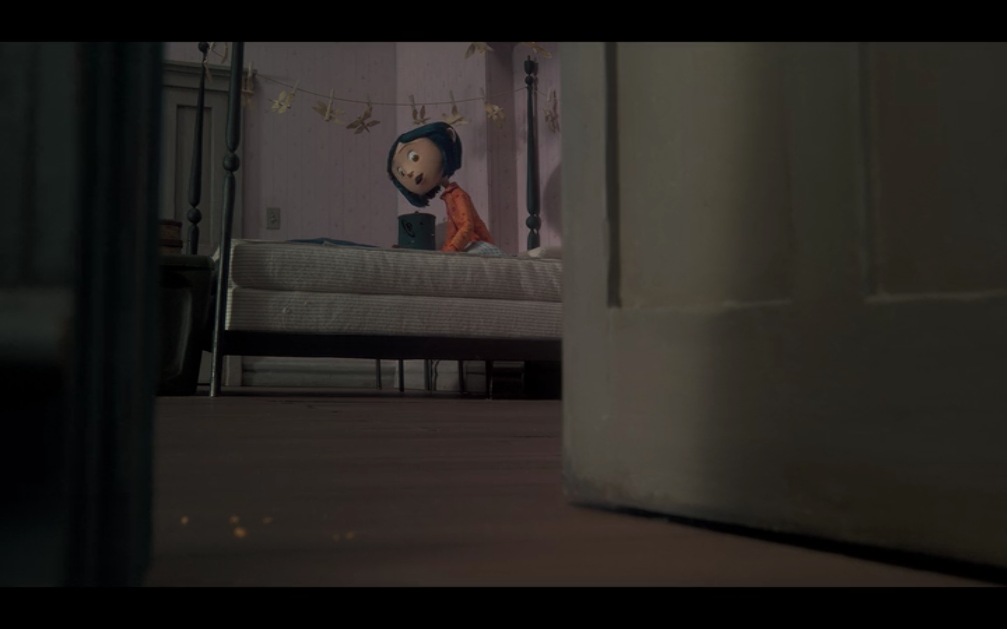 practice film vocabulary and analysis with coraline. low viewpoint shot of Coraline sitting on her bed.